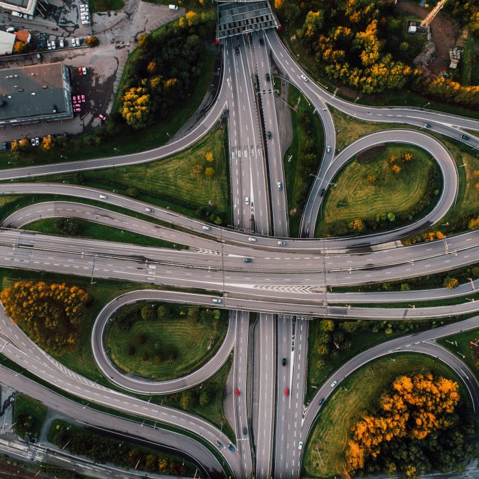 An aerial shot of twisted roads surrounded by parks in the middle of the city